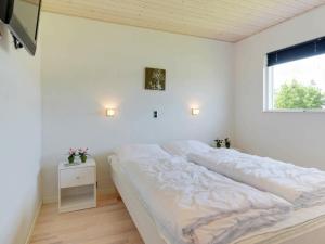 a white bedroom with a bed and a window at Three-Bedroom Holiday home in Hemmet 52 in Hemmet