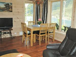 comedor con mesa, sillas y TV en Two-Bedroom Holiday home in Olden 3, en Olden