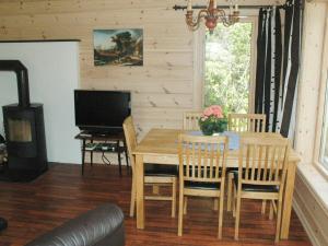 comedor con mesa, sillas y TV en Two-Bedroom Holiday home in Olden 3, en Olden