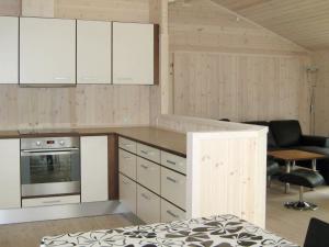 a kitchen with white cabinets and a living room at 6 person holiday home in Silkeborg in Engesvang