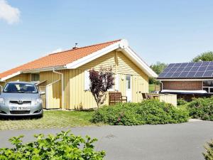 オッテルンドルフにある6 person holiday home in Otterndorfの太陽光パネル付きの家の前に停車する車