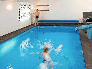 a young boy in a swimming pool with a ball at 18 person holiday home in Idestrup in Marielyst