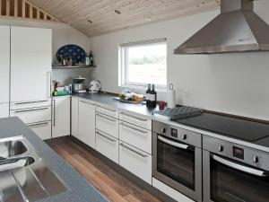 a kitchen with white cabinets and a stove top oven at 18 person holiday home in Idestrup in Marielyst
