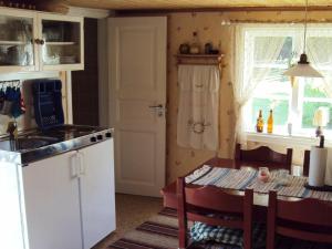 een keuken met een tafel en een witte koelkast bij Two-Bedroom Holiday home in Lessebo in Skruv