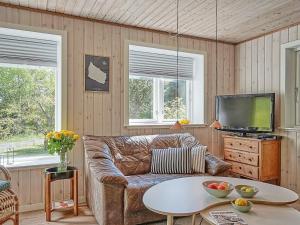 Vester Sømarkenにある6 person holiday home in Aakirkebyのリビングルーム(革張りのソファ、テレビ付)