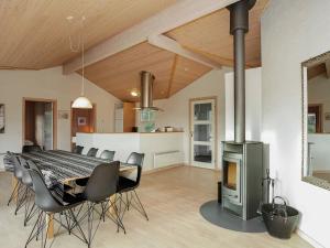a dining room with a table and a fireplace at 8 person holiday home in Jerup in Jerup