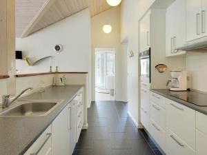 a kitchen with white cabinets and a sink at 8 person holiday home in Tarm in Hemmet