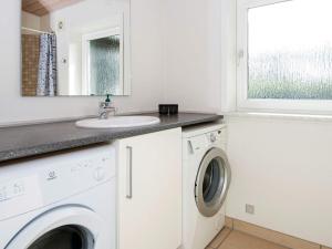 a bathroom with a sink and a washing machine at 8 person holiday home in Tarm in Hemmet