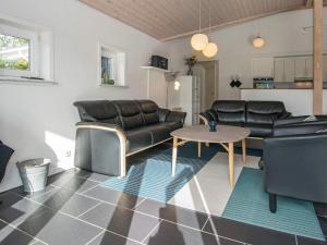 a living room with leather furniture and a table at 8 person holiday home in Tarm in Hemmet