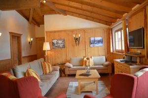 a living room with two couches and a tv at Penthouse Kitzpanorama in Kaprun