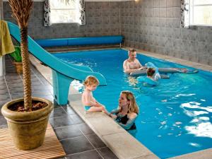 una familia jugando en la piscina del parque acuático en 22 person holiday home in Sydals, en Sønderby