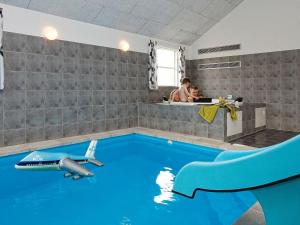 a room with a pool with a plane on the wall at 22 person holiday home in Sydals in Sønderby