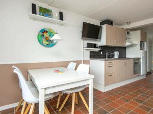 kuchnia i jadalnia z białym stołem i krzesłami w obiekcie Holiday Home Golfvejen II w mieście Fanø