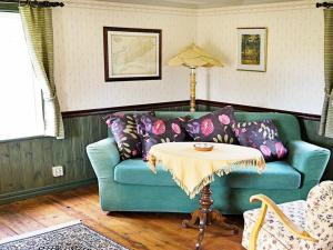 4 person holiday home in ANKARSRUM في Hult: غرفة معيشة مع أريكة زرقاء وطاولة
