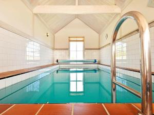an indoor swimming pool with blue water at 12 person holiday home in Sk rhamn in Skärhamn