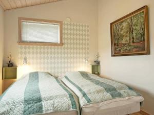 1 dormitorio con 1 cama y una foto en la pared en 4 person holiday home in Gudhjem, en Gudhjem