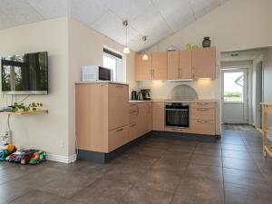 a kitchen with wooden cabinets and a stove top oven at 8 person holiday home in Ansager in Ansager