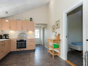 una cocina con armarios de madera y una mesa en una habitación en 8 person holiday home in Ansager, en Ansager