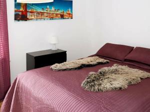 a bed with a purple comforter with a furry blanket at Apartment LAHOLM in Laholm