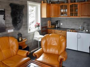 ErvikにあるHoliday home Urangsvåg IIのキッチン(革張りの椅子2脚、カウンタートップ付)