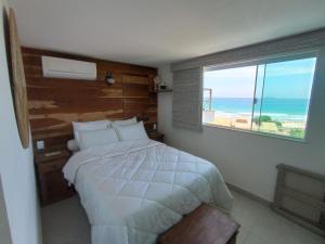 una camera con letto e vista sull'oceano di Lofts do Morro Magico a Búzios