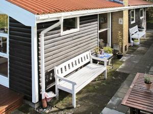 a white bench sitting on the side of a house at 5 person holiday home in Stege in Stege