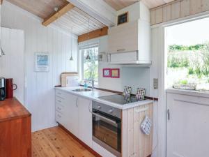 a kitchen with white cabinets and a sink and a window at 5 person holiday home in Stege in Stege