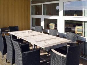 ノーポにある8 person holiday home in Nordborgの木製テーブルと椅子付きのパティオ