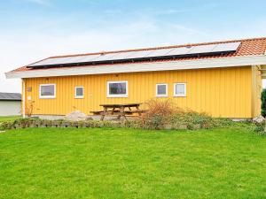ノーポにある8 person holiday home in Nordborgの太陽光パネル付黄色の家