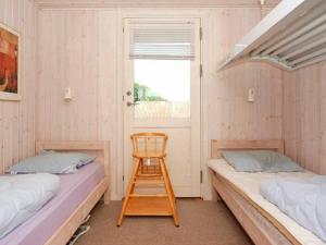 HejlsにあるThree-Bedroom Holiday home in Sjølund 4のベッド2台、椅子、窓が備わる客室です。