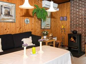 a living room with a table with a couch and a fireplace at 6 person holiday home in R m in Bolilmark