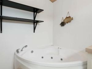 uma casa de banho com uma banheira com um bicho na parede em 8 person holiday home in Hals em Hals