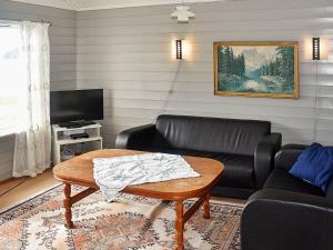 un soggiorno con divano in pelle nera e tavolo di 7 person holiday home in Selje a Selje