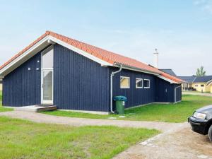 ein blaues Haus mit einem davor geparkt in der Unterkunft 8 person holiday home in Gro enbrode in Großenbrode