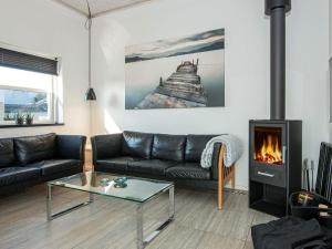 a living room with a couch and a fireplace at 6 person holiday home in Juelsminde in Sønderby