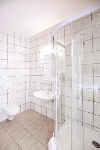 a bathroom with a shower and a toilet and a sink at Best Deal Airporthotel Weeze in Weeze