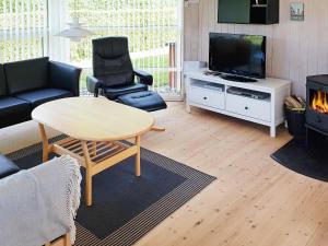 Binderup Strandにある6 person holiday home in Bjertのリビングルーム(ソファ、テーブル、テレビ付)