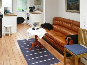 a living room with a brown leather couch and a table at Holiday Home Hamngatan in Nordvik