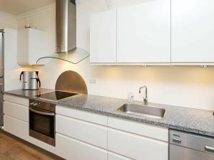 a kitchen with white cabinets and a sink at 6 person holiday home in Skagen in Skagen