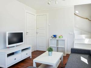 a living room with a tv on a white cabinet at Holiday Home Herrestadsberg in Uddevalla