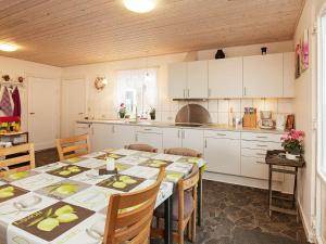 ロービュにある6 person holiday home in R dbyのキッチン(テーブル、椅子付)、キッチン(白いキャビネット付)