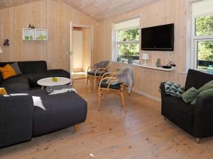 een woonkamer met 2 banken en een tv bij Holiday Home Skovbrynet II in Odde