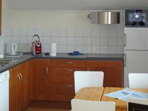 una cocina con armarios de madera y una mesa con sillas. en Two-Bedroom Holiday home in Leikanger, en Leikanger