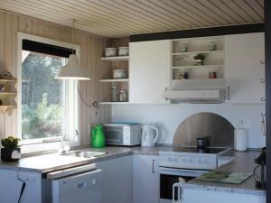 uma cozinha com um lavatório e um fogão forno superior em Three-Bedroom Holiday home in Vejby 14 em Blåvand