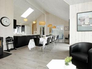 - une salle à manger et une cuisine avec une table et des chaises dans l'établissement 18 person holiday home in Bl vand, à Blåvand