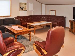 OksvollにあるHoliday Home Steinvikのリビングルーム(革張りのソファ、テーブル付)