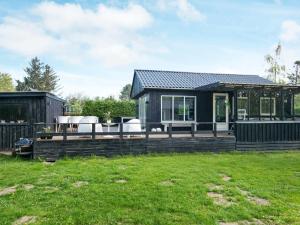 een huis met een terras met stoelen erop bij 6 person holiday home in Odder in Odder
