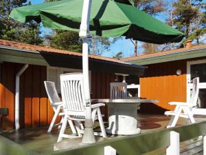 einen Tisch und Stühle mit einem Sonnenschirm auf einer Terrasse in der Unterkunft 10 person holiday home in V ggerl se in Bøtø By