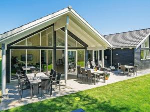a patio with tables and chairs and glass doors at 18 person holiday home in Hasselberg in Kappeln