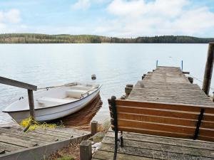 un bateau est amarré à un quai sur un lac dans l'établissement 4 person holiday home in VETLANDA, à Lillarp